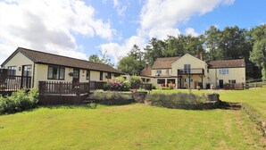 A row of two-story houses with a grassy yard in front, wooden fences, and a clear sky. - The Rock Self Catering Holiday Accommodation (Coleford)