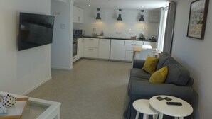 A modern apartment with a living room, kitchen, and dining area. - The Rock Self Catering Holiday Accommodation (Coleford)