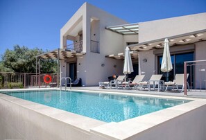 A modern building with a swimming pool, sun loungers, and umbrellas. - Villa Alkistis in Lefkada (Lefkada)