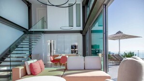 Un intérieur moderne comprenant un escalier, un coin repas et un espace salon avec vue.