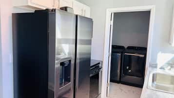 A kitchen with a black refrigerator, a microwave, and a dishwasher.