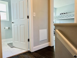 Enter a serene bedroom with a bunk bed and patterned bedspread, featuring a white headboard.