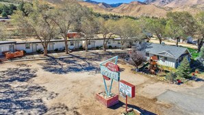 A motel with a sign indicating 'West Walker Motel' in a desert landscape with mountains in the background.