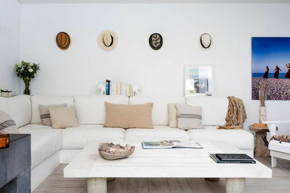 A modern living room with a white sofa, a coffee table, and a bookshelf.