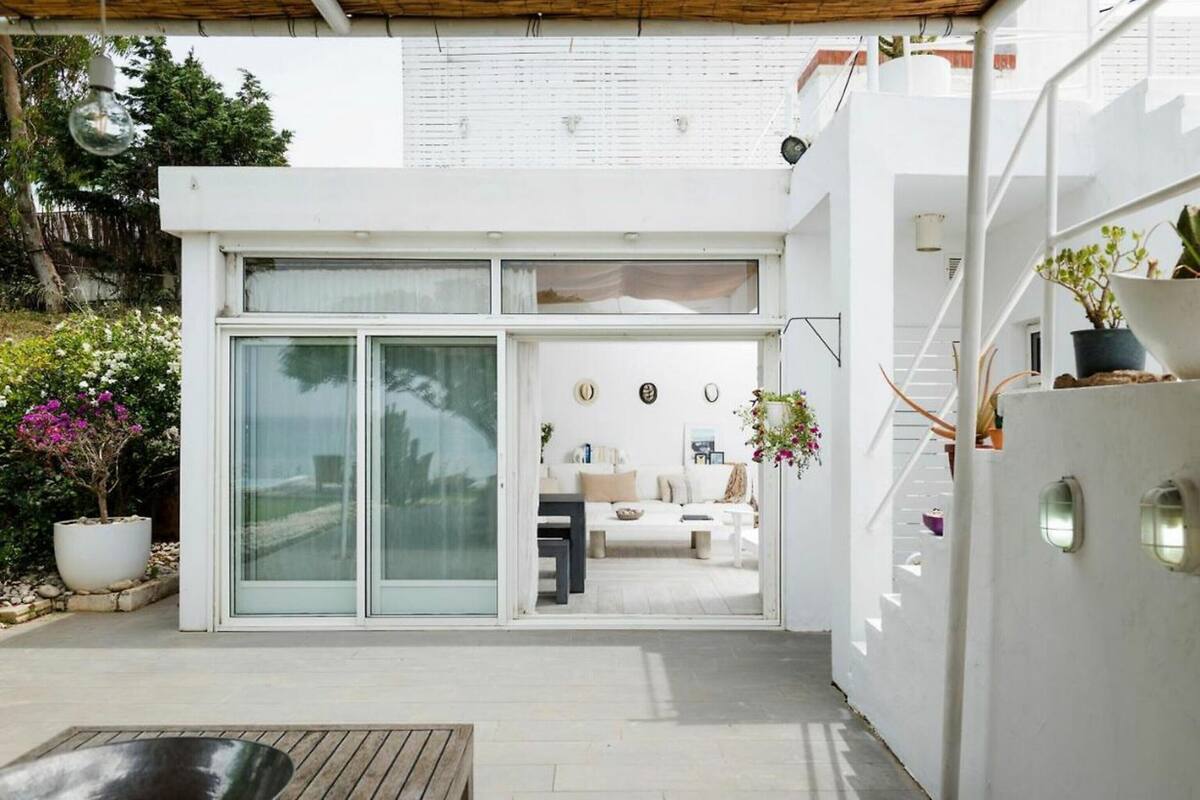 A modern house with a glass door entrance leading to a living area with a sofa and a coffee table.