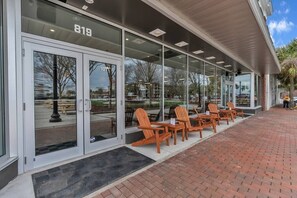 Guests can relax in the covered outdoor seating area with comfortable chairs and tables.