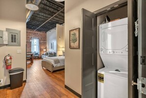 Relax in a spacious room with a large bed, seating area, and convenient washing machine.