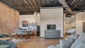 A modern interior with a kitchen, dining area, and living room. - Sip, Stay, Play  Loft Above a Brewery (Myrtle Beach)