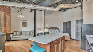 Una cocina moderna con una isla central, armarios de madera y un comedor con sofá y sillas.