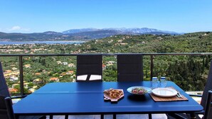 A table set for two with a view of a mountainous landscape and a body of water. - Villa Alba in Lefkada (Lefkada)