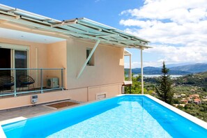 Ein modernes Haus mit Pool, großen Fenstern und Blick auf die Landschaft.