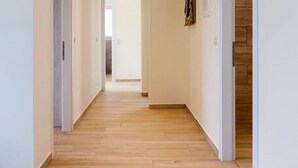 A hallway with wooden flooring, white walls, and a door at the end. - Villa Alba in Lefkada (Lefkada)