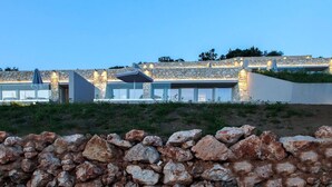 A modern building with stone walls and large windows, likely a hotel or resort. - Syvota 08 Sunset 2B Zara (Igoumenitsa)