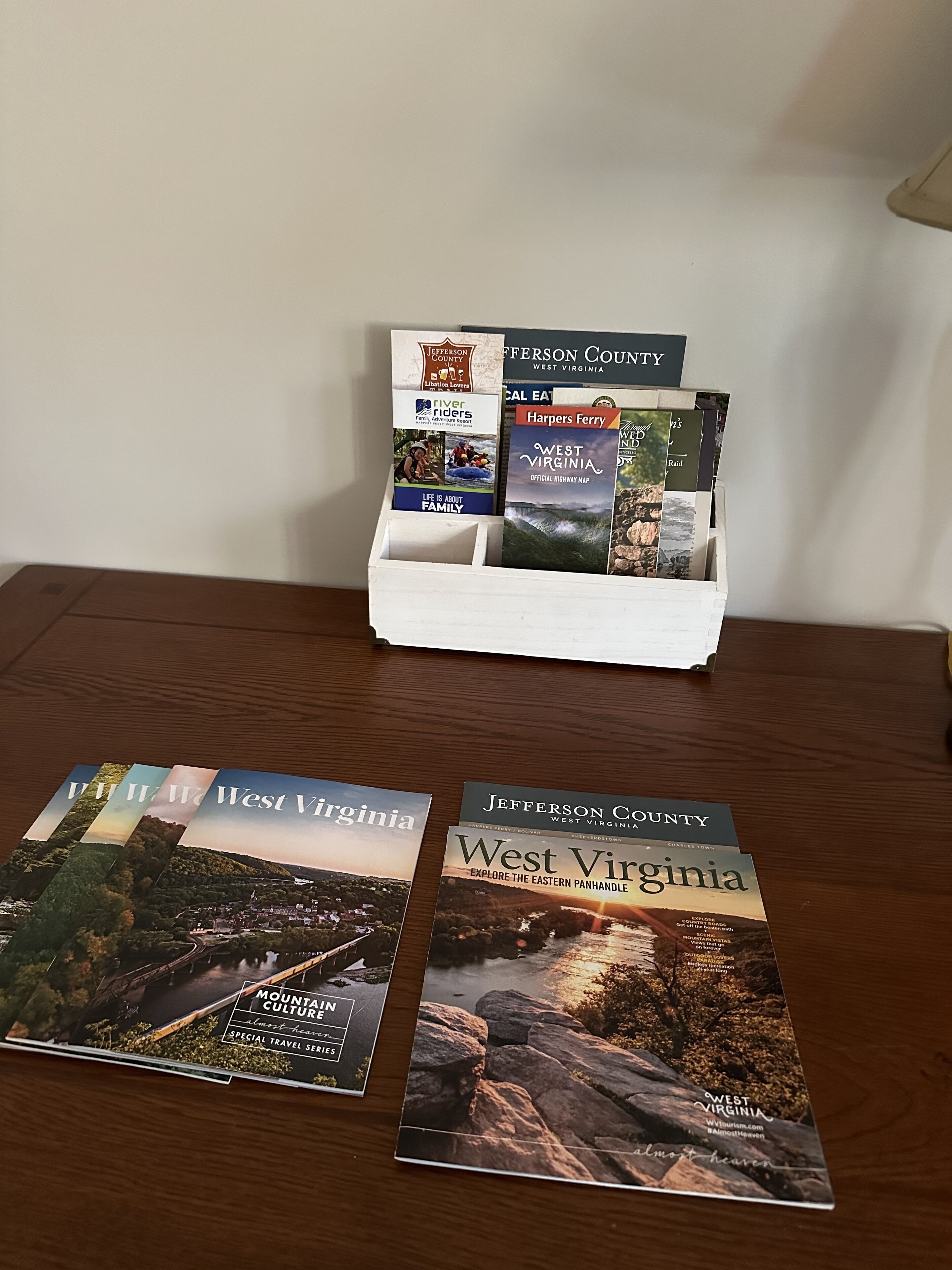 A wooden table with brochures for West Virginia and Jefferson County.