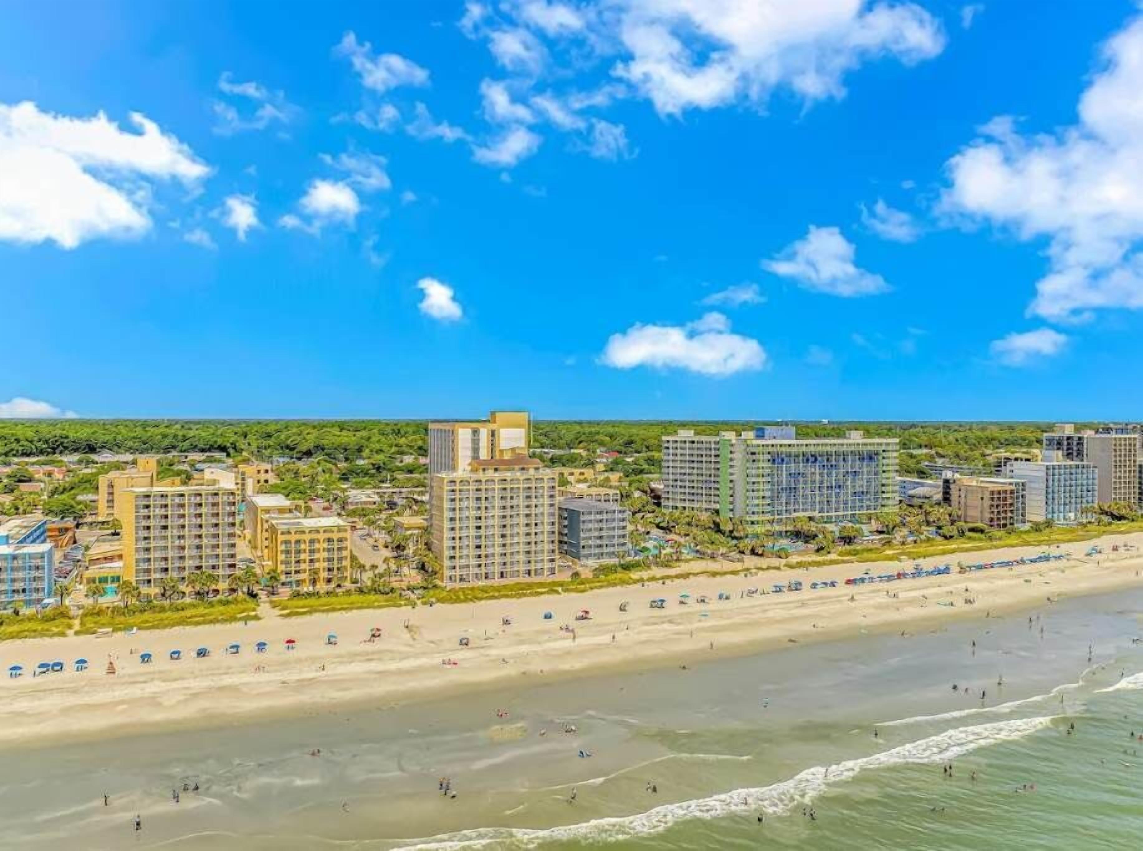 Eine Küstenstadt mit Strandhotels, Sandstränden und blauem Himmel.