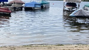 En sandstrand med båtar som ligger förtöjda i bakgrunden.