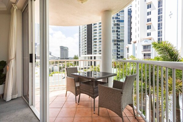 Enjoy a balcony with a round table and four chairs, offering a view of the surrounding high-rise buildings.