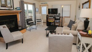 Ein gemütliches Wohnzimmer mit Kamin, Fernseher, Sofa und Bücherregal.