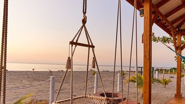 A wooden deck with a swing set overlooking a beach. - Cozy cabin with océan view (Omoa)