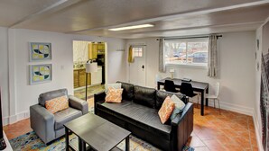 A living room with a sofa, armchairs, a coffee table, and a dining area with a table and chairs. - Hyde Park Hyde Out Apt 5 (Boise)
