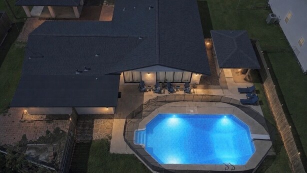 Propiedad residencial con piscina, patio cubierto y jardín cercado.