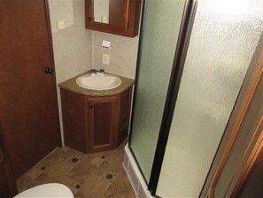 Sink and mirror in a compact bathroom with a door to an adjacent room.