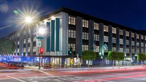 A modern hotel with a prominent corner location, large windows, and a well-lit facade. - Marriott Vacation Club Pulse, SF (San Francisco)