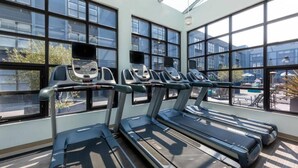 A gym with treadmills and exercise equipment, large windows, and a view of the outside. - Marriott Vacation Club Pulse, SF (San Francisco)