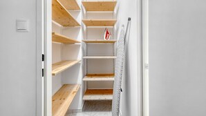 A narrow hallway with wooden shelves and a towel hanging on the wall. - Refurbished Penzing 3BR w/ Elevator & Balcony, nr metro U3, by Blueground (Vienna)