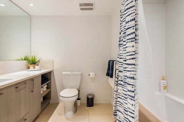 A modern bathroom with a toilet, sink, and shower area.
