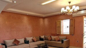 Amplio salón con un sofá modular grande, una mesa de centro y una araña.