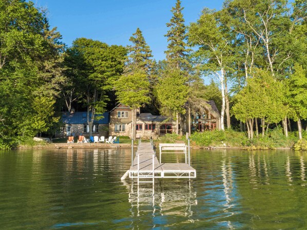 A lakeside cabin with a dock, surrounded by trees and a clear sky. - Private Estate, Kangaroo East Shore! (Baileys Harbor)