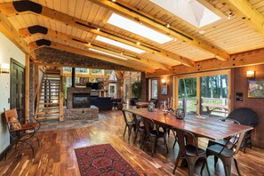 A spacious interior with a wooden dining table, chairs, a fireplace, and a staircase leading to an upper level. - Private Estate, Kangaroo East Shore! (Baileys Harbor)
