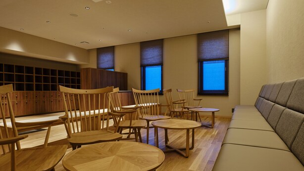 A modern lounge area with wooden furniture, including chairs and tables, and a sofa. - Lake Toya Tsuruga Resort Hikari no uta (Sobetsu)
