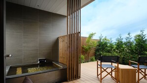 Ein moderner Außenbereich zum Entspannen mit Whirlpool, Holzterrasse und Sitzgelegenheiten.