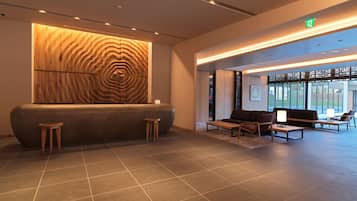A modern reception area with a wooden wall, seating, and a view of the outdoors.