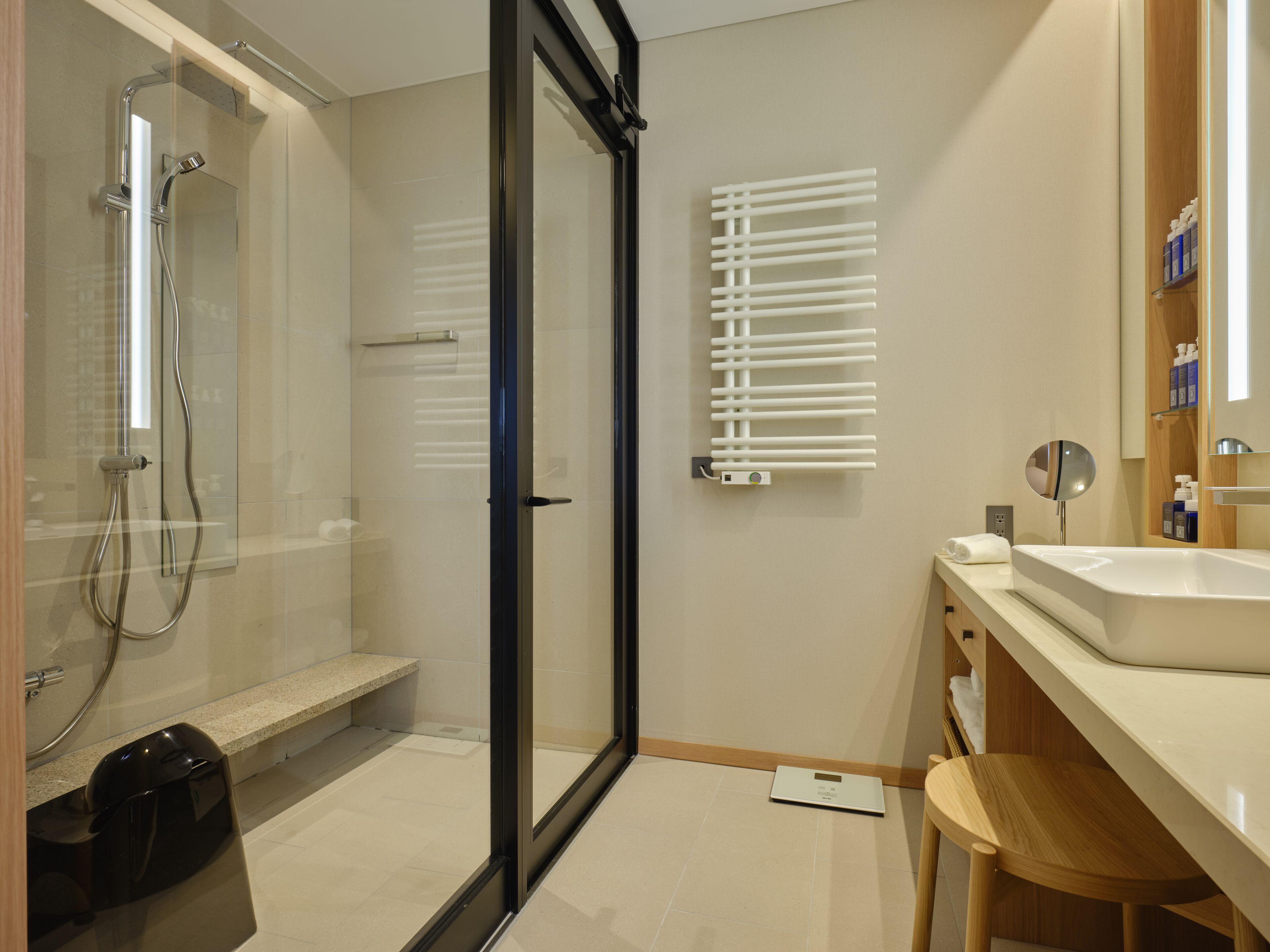 Une salle de bain moderne dotée d’une douche à parois de verre, de toilettes intégrées, d’un lavabo et d’un miroir.