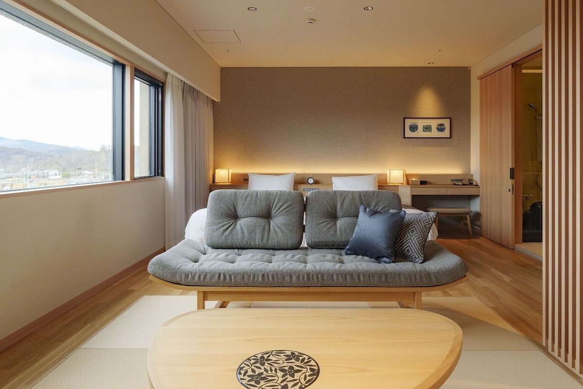 Una habitación de hotel moderna con sofá, una mesita y vistas a la ciudad.
