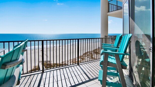 A balcony with turquoise chairs and a view of the beach. - The Oasis 610 | Spacious, Lazy River, Poolside Grill, New Splash Pad, Pool with Slide! (Orange Beach)