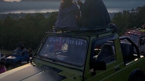 A vehicle with a "OFFROAD" sign, parked on a hill overlooking a landscape with mountains and a body of water. - a very interesting tour held on top of Mount Batur, 4wd jeeps tour (Bali)
