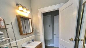 A bathroom with a toilet, sink, vanity, and a mirror. - Historical Spacious 1-Bedroom Apartment Unit 3 (Shreveport)