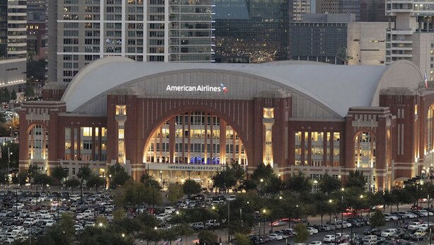 A large airport terminal with the American Airlines logo, surrounded by tall buildings and a parking lot. - Safe, Central, Cozy Home with Private Parking, KING Bed, near DFW Airport & more (Euless)