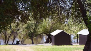 A lakeside cabin with a grassy area and a pond. - Cabin 3 | Rural Oasis on Pond with Panoramic Views (Latah County)