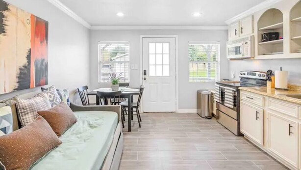 Un espacio habitable compacto con kitchenette, comedor y dormitorio.