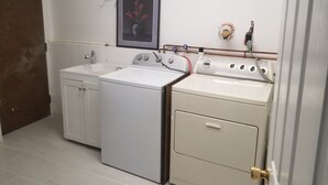 Une cuisine de taille réduite équipée d’un lave-linge, d’une cuisinière et d’un évier.