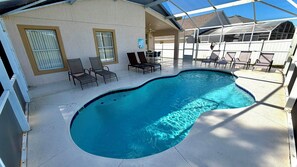 En swimmingpool med liggestole og en overdækket terrasse.