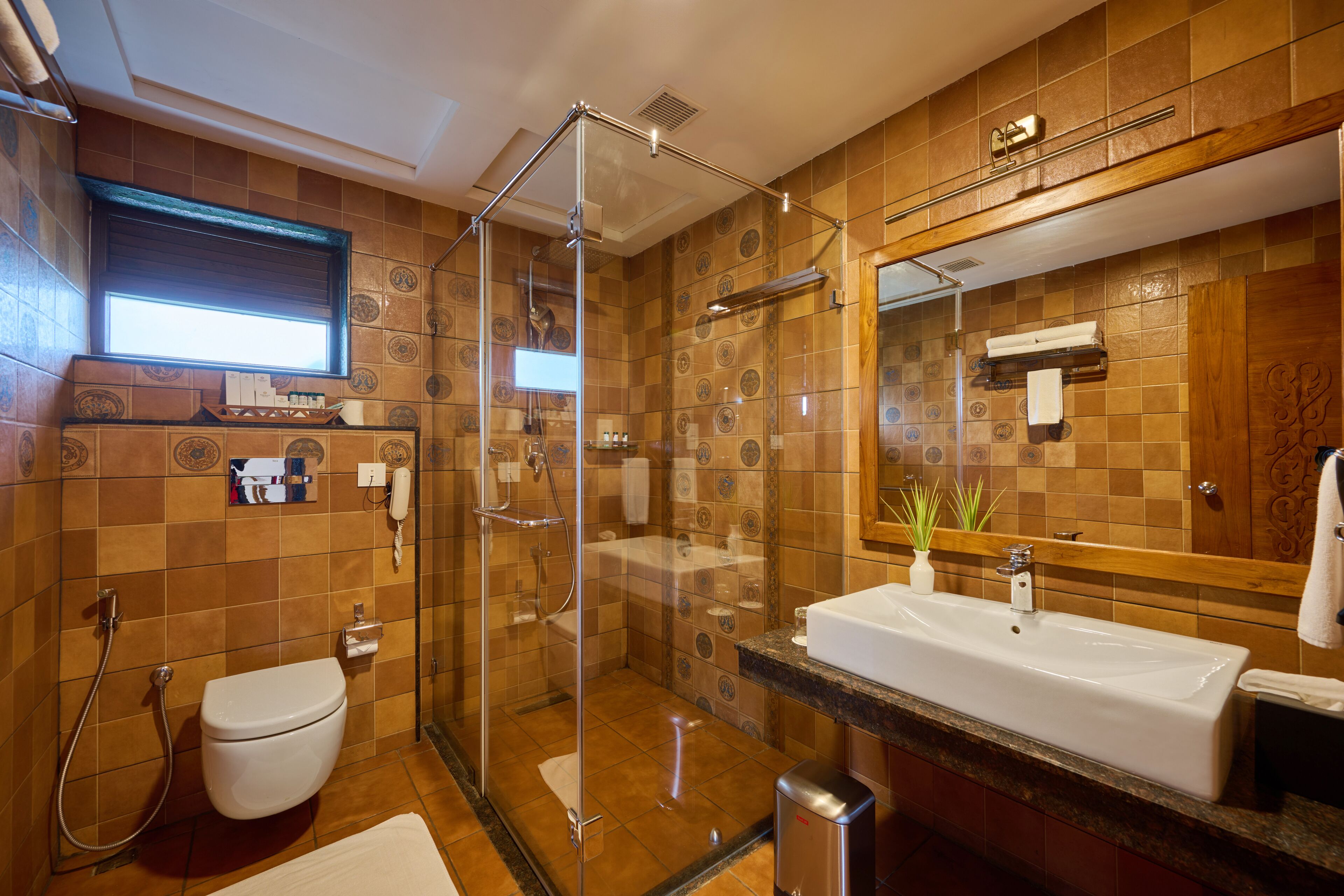 A bathroom with a glass-enclosed shower, a white sink, and a large mirror.