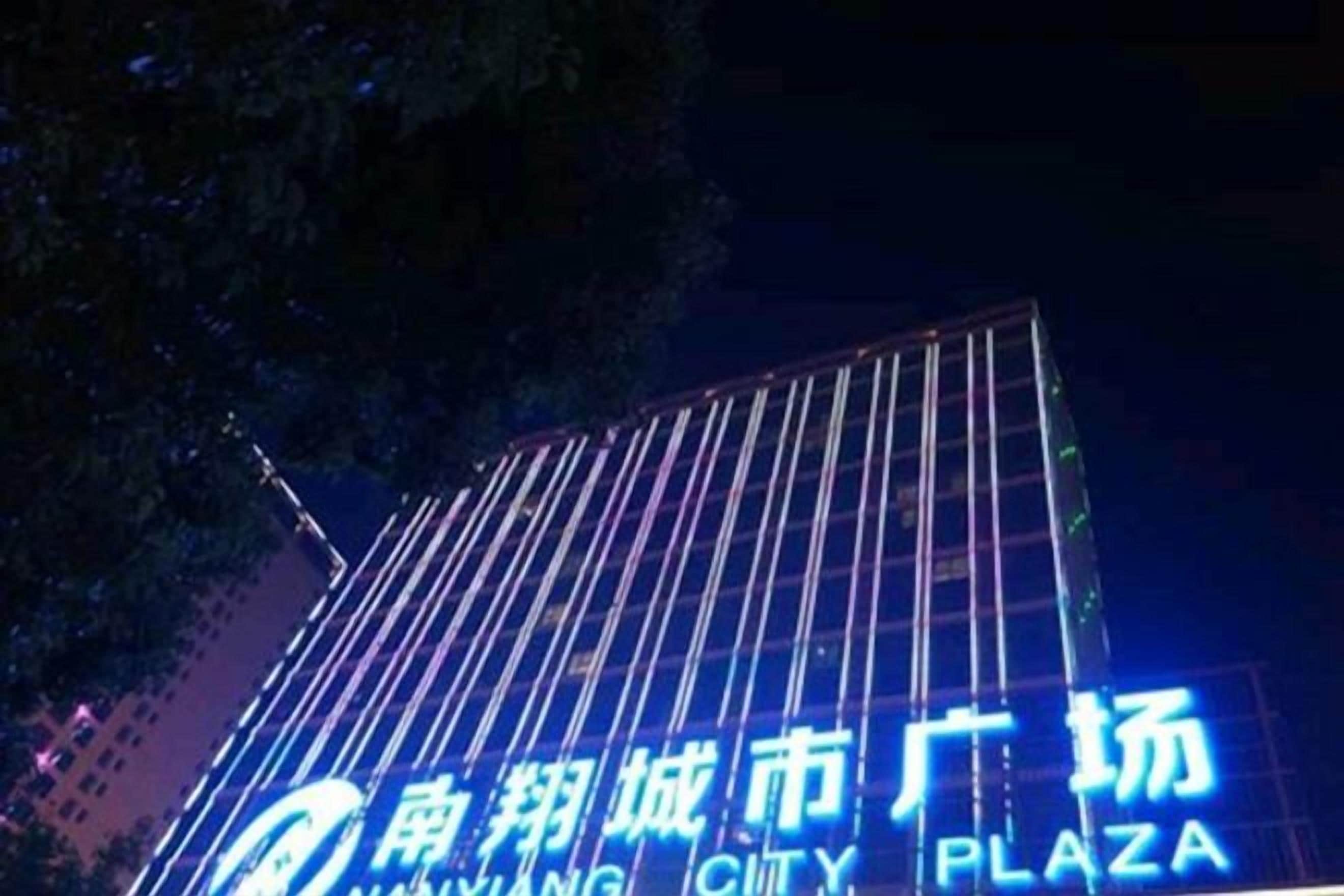 Un edificio con señalización iluminada que indica 'Nanjing City Plaza'.