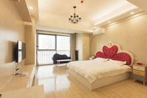 A modern bedroom with a large bed, a television, a desk, and a balcony. - Mango Hotel (Bengbu)
