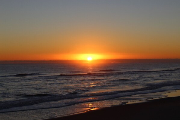 A sunset over the ocean with waves.